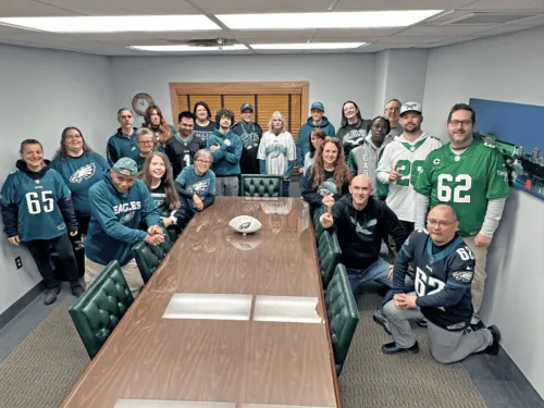 John Evans' Sons employees gathered around the conference table in their Eagles gear.